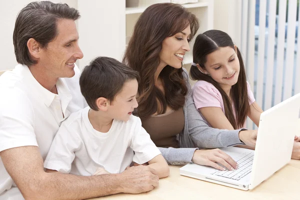 Familia feliz que se divierte usando el ordenador portátil en casa — Foto de Stock