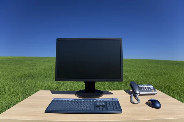 Desk and Computer In Green Field — Stock Photo, Image