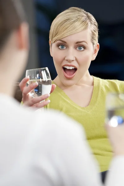 Meglepett, fiatal, szőke nő iszik, egy barát — Stock Fotó