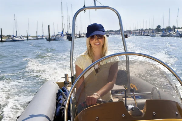 驾驶一艘快艇的美丽年轻的金发女人 — 图库照片