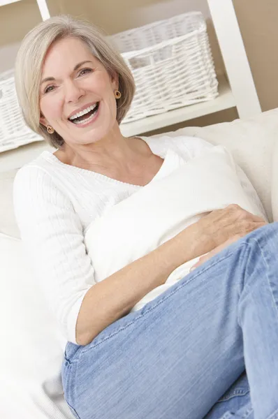 Привлекательная счастливая пожилая женщина, смеющаяся дома — стоковое фото