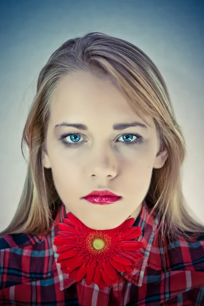 Portret van een jonge vrouw met heldere rode bloemen. — Stockfoto