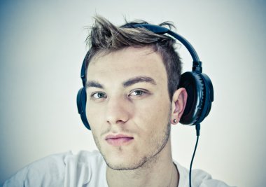 Portrait of a happy young man listen music with headphones clipart