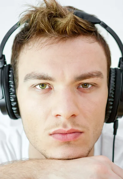 Portrait of young man with headphones listening to music on a wh — Stock Photo, Image