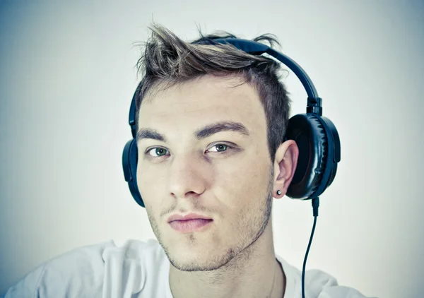 Porträt eines glücklichen jungen Mannes, der mit Kopfhörern Musik hört — Stockfoto