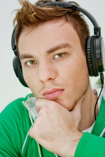 Egy boldog fiatalember portréja, hallgatni a zenét a fejhallgató — Stock Fotó