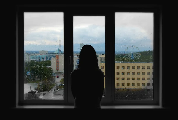 Ensam man tittar ut genom fönstret Stockfoto