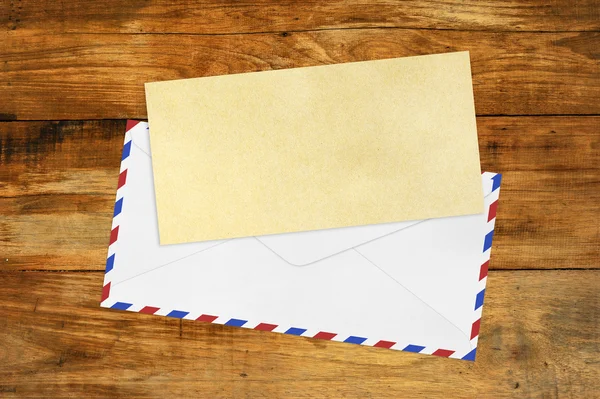 Vintage envelop met blanco bruin papier op hout — Stockfoto