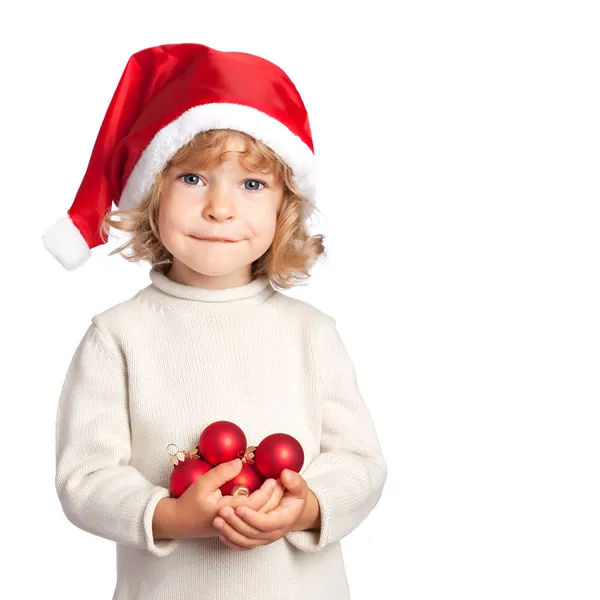 Criança sorridente em chapéu de Santa com bolas de Natal no backgro branco — Fotografia de Stock
