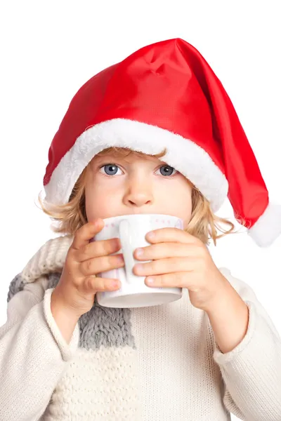 Sıcak çikolata içme Noel Baba şapkalı çocuk — Stok fotoğraf