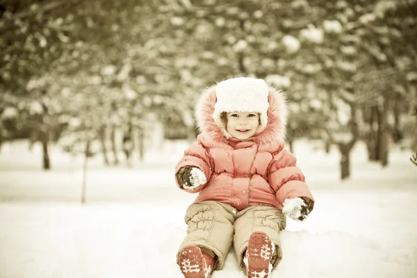 Kind spielt auf Schneebällen — Stockfoto