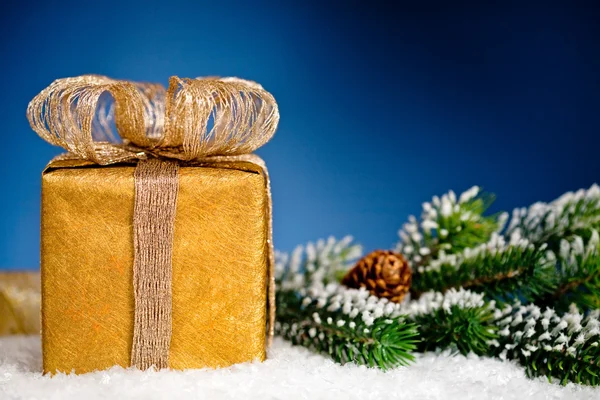 雪の中のギフト ボックスとクリスマス ツリー ブランチ — ストック写真