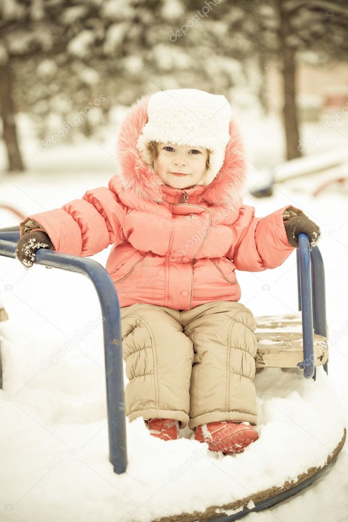 Baby playing on snow in winter