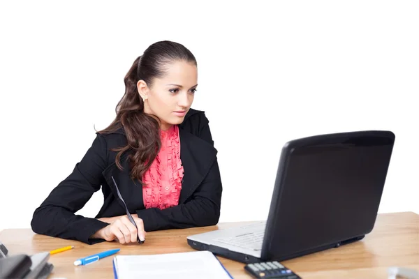 Молодая женщина, сидящая за офисным столом и работающая на лапте — стоковое фото