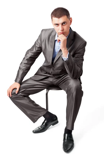 Уверенный в себе портрет бизнесмена, сидящего на стуле, изолированном на полу. — стоковое фото