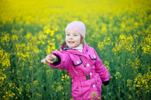 Dziewczynka w dziedzinie żółte kwiaty — Zdjęcie stockowe