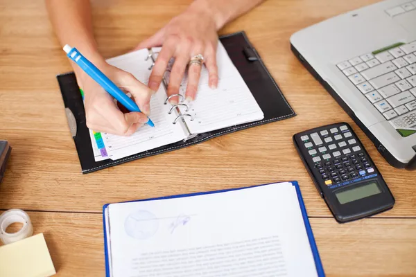 Business woman writing in a notebook — Stock Photo, Image
