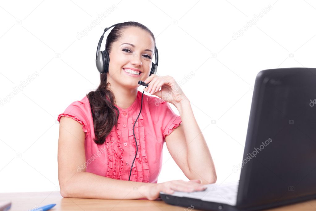 Young happy smiling woman sitting at office desk with headset is
