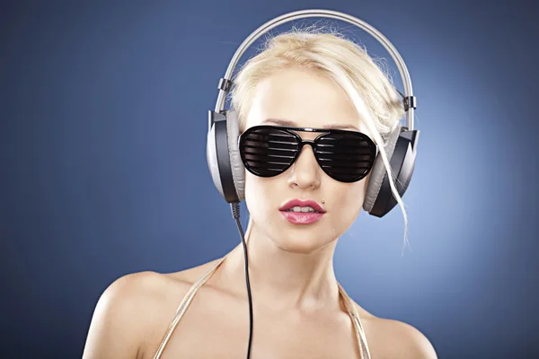 Portrait of a beautiful model with headphones and sunglasses — Stock Photo, Image