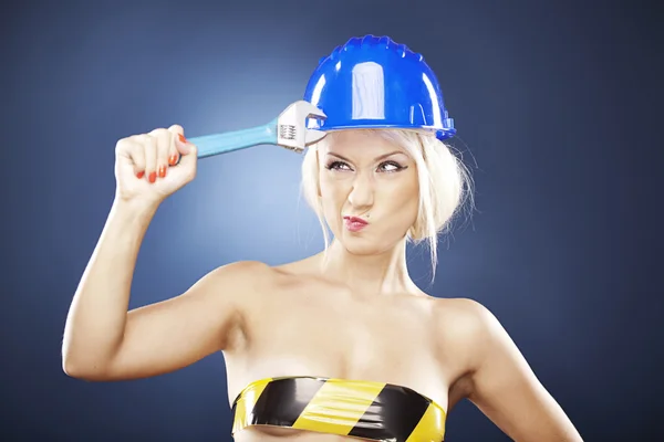 Beautiful blonde model with adjustable wrench. — Stock Photo, Image