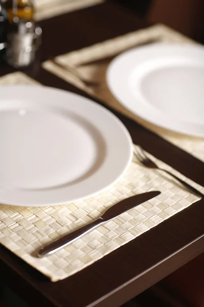 Gros plan avec une belle assiette blanche et un couteau à steak pointu . — Photo
