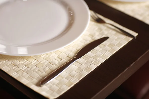 Gros plan avec une belle assiette blanche et un couteau à steak pointu . — Photo
