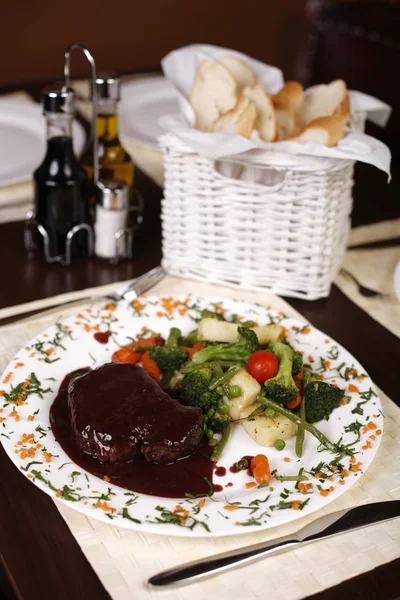 Элегантная ресторанная тарелка с большим стейком и подливкой с гарниром — стоковое фото