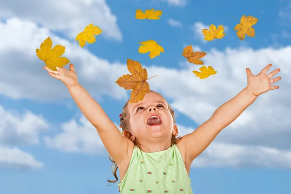 Щаслива кричить маленька дівчинка з осіннім листям — стокове фото