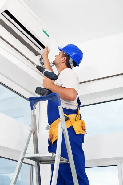 Worker mounting air conditioning unit — Stock Photo, Image