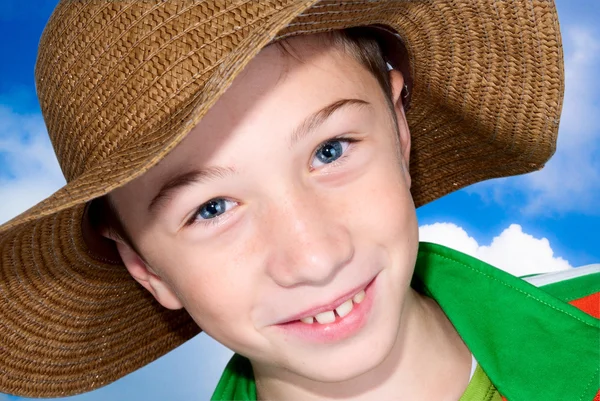 Niño con sombrero de paja y cielo azul — Foto de Stock