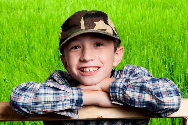 Uśmiechnięty chłopiec na tle pola — Zdjęcie stockowe