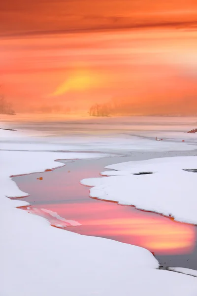 Ручей течет через замерзшее озеро — стоковое фото