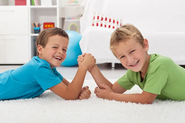 Mutlu çocuklar gülüyor ve bilek güreşi — Stok fotoğraf