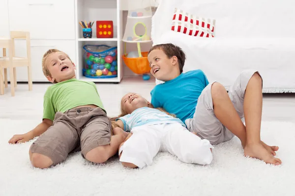 Glada barn som leker på golvet — Stockfoto