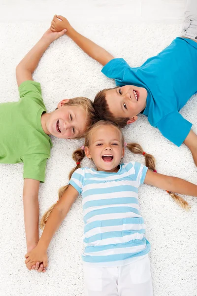Glada skrattande barn på golvet — Stockfoto