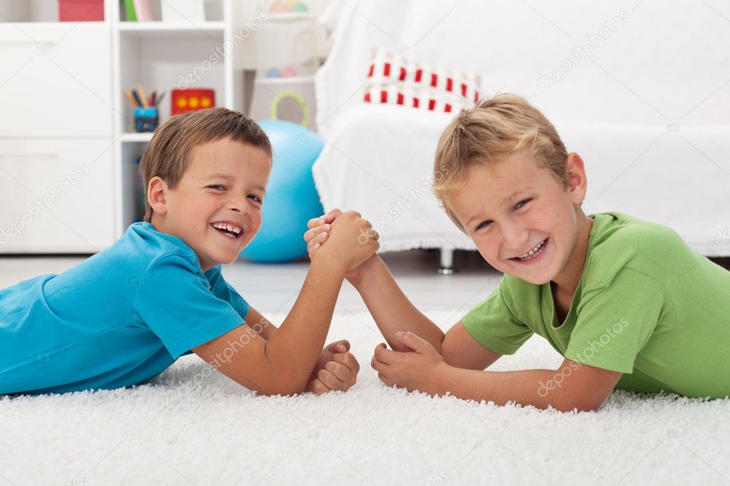 Happy boys laughing and arm wrestling