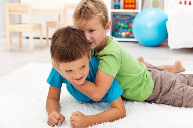 Kids wrestling on the floor clipart