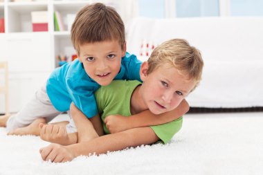 Kids wrestling on the floor - boys game clipart