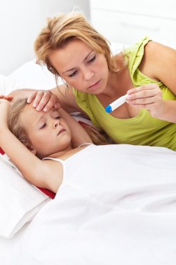 Woman checking her daughter's temperature clipart