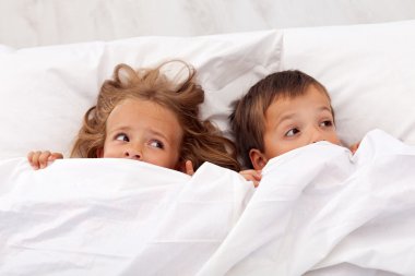 Kids afraid pulling the quilt on their heads clipart