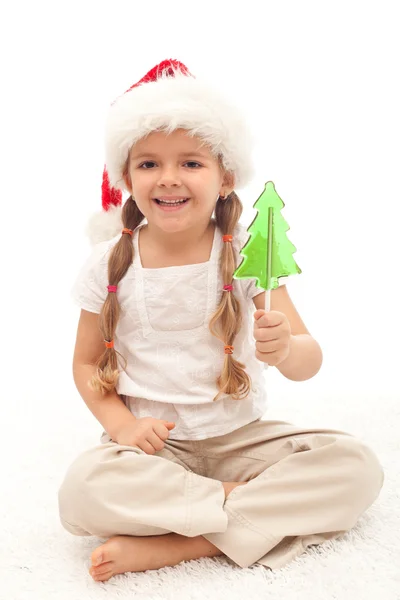 Meisje met kerst hoed en boom shape lollipop — Stockfoto