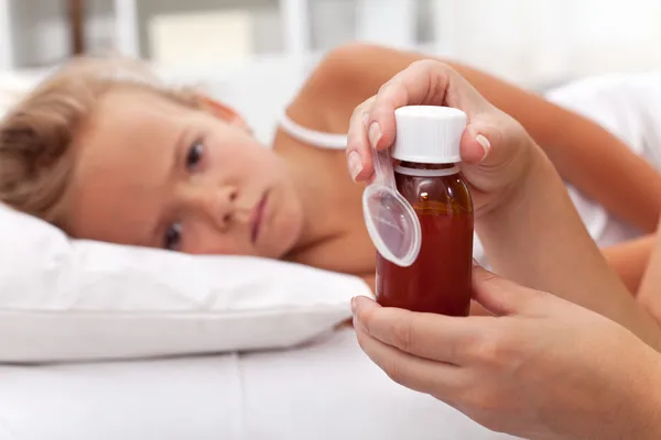 Sick child awaits medication syrup — Stock Photo, Image