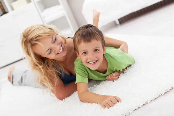Boldog anya és fia játszik a nappaliban — Stock Fotó