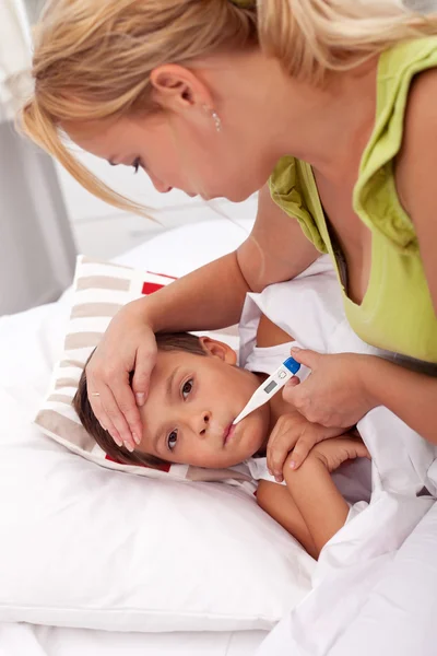 Жінка перевіряє температуру маленького хлопчика — стокове фото