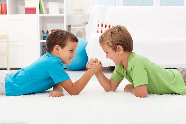 Мальчики армрестлинг в детской комнате — стоковое фото