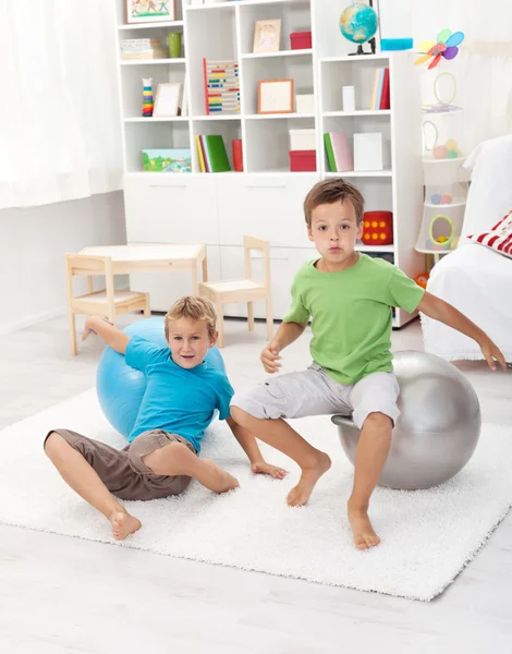 Boys jumping on large gymnastic balls and falling — Stock Photo, Image