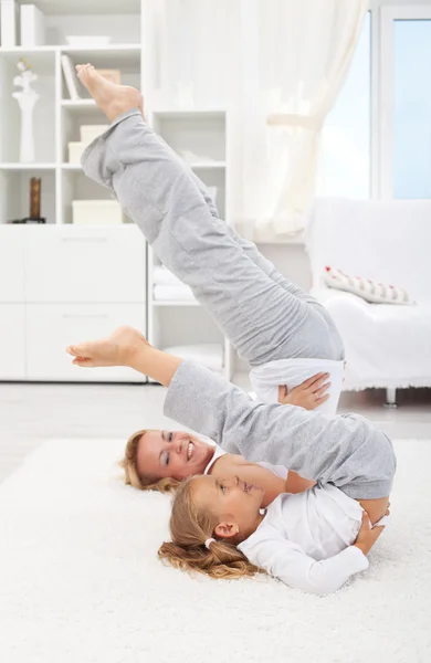 Vrouw en meisje gymnastische oefening doet — Stockfoto
