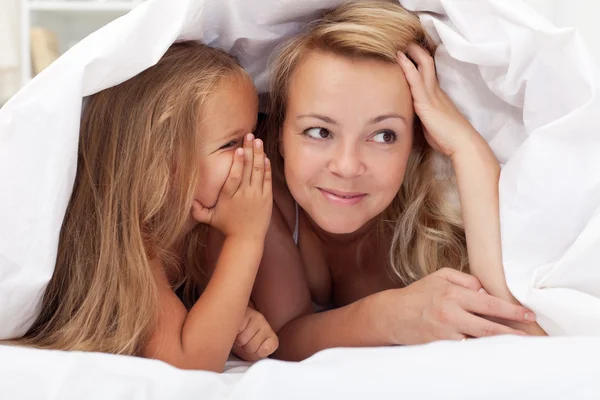 Moeder en klein meisje samen onder het dekbed — Stockfoto