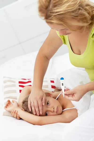 Мати перевіряє температуру дітей — стокове фото