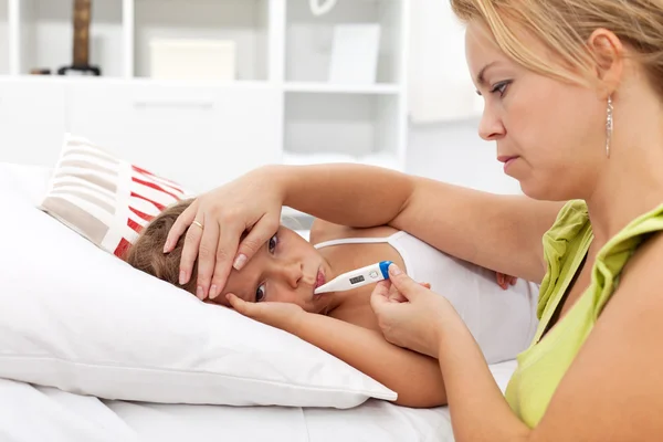 Criança doente com febre alta e uma mãe preocupada — Fotografia de Stock